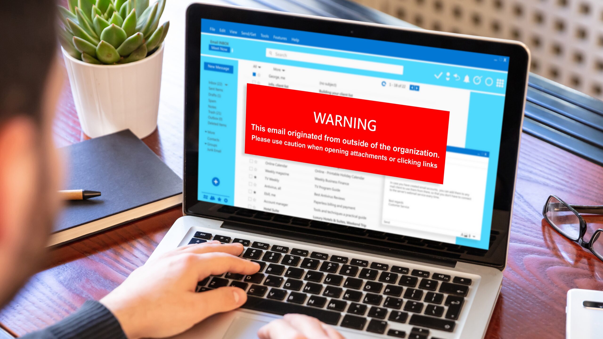 Email attachments warning message on a laptop screen.