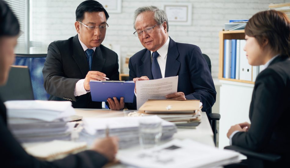 Professional Vietnamese lawyer consulting his coworker